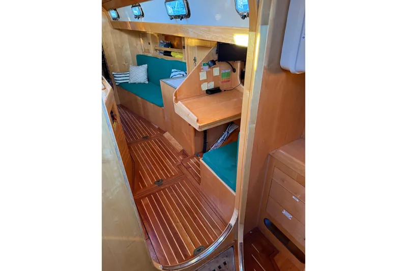 Slide: The Image of Interior of 2007 Chuck Burns Custom 49' Schooner with wooden finish and green seating. - 54