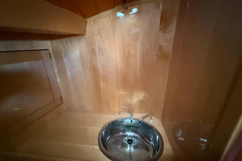 Slide: The Image of Wood-paneled interior with a small metal sink on a 2007 Chuck Burns Custom 49' Schooner. - 62