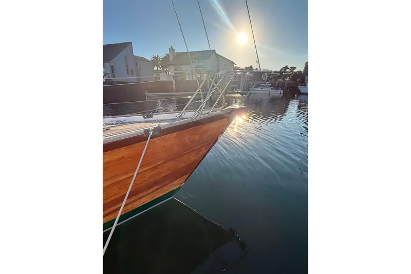 Slide: The Image of Chuck Burns Custom 49' Schooner, 2007, docked at sunset with wooden hull reflecting sunlight. - 8