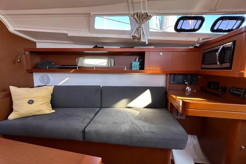 Slide: The Image of Interior of 2015 Beneteau Oceanis 37 yacht with sofa, wooden cabinetry, and modern amenities. - 15