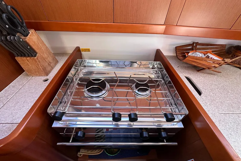 Slide: The Image of Compact kitchen stove on 2015 Beneteau Oceanis 37 yacht with wooden cabinetry and knife block. - 19