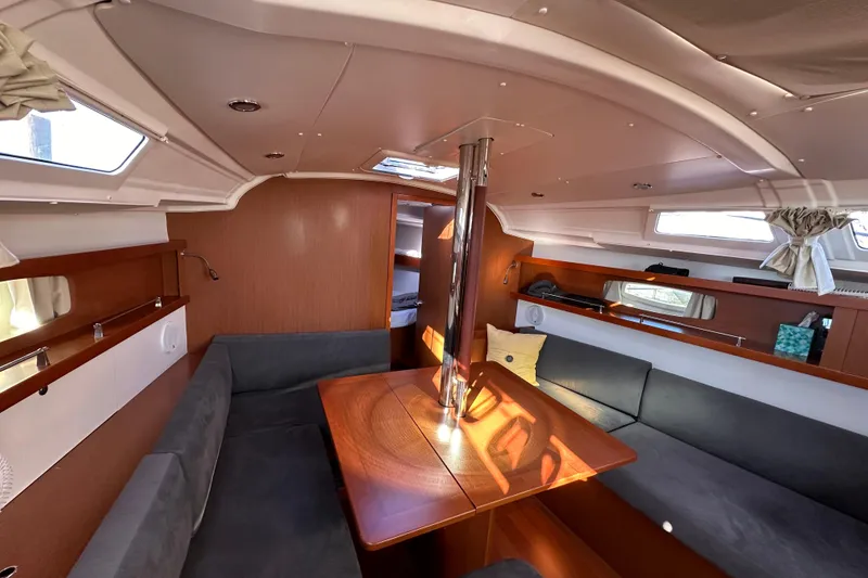 Slide: The Image of 2015 Beneteau Oceanis 37 interior with cozy seating and wooden table. - 26
