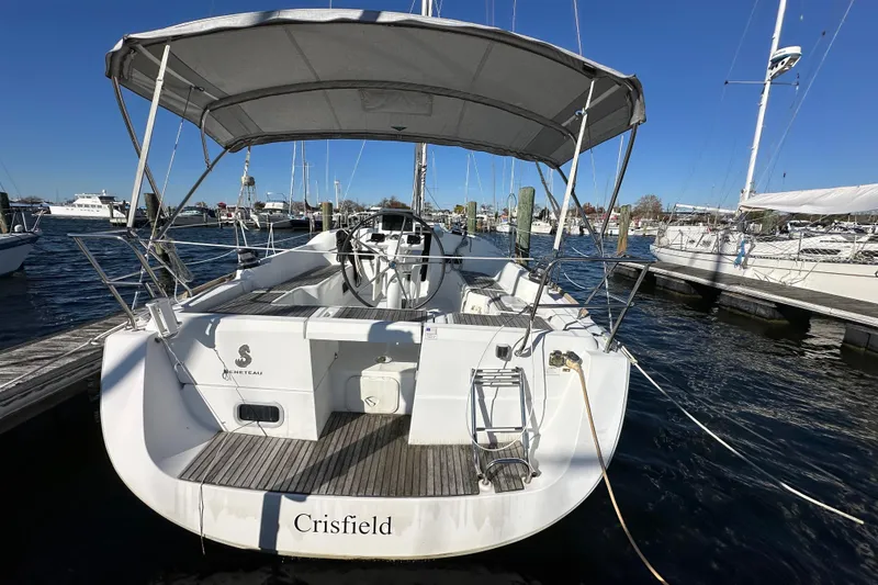 Slide: The Image of 2015 Beneteau Oceanis 37 sailboat docked, rear view with canopy and steering wheel. - 4