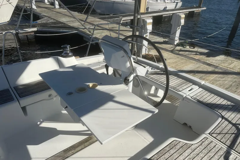 Slide: The Image of Cockpit of 2015 Beneteau Oceanis 37 sailboat with steering wheel and table, docked at marina. - 6