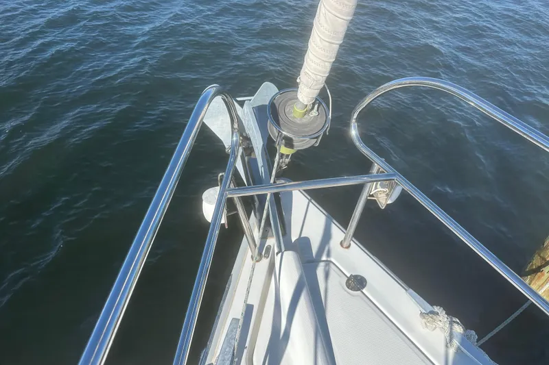 Slide: The Image of Beneteau Oceanis 37 sailboat bow, 2015 model, with stainless steel railings over water. - 9