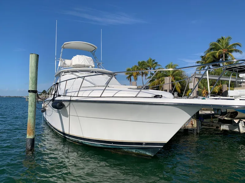 Slide: The Image of 1999 Tiara Yachts 43 Open docked in sunny marina with palm trees. - 14