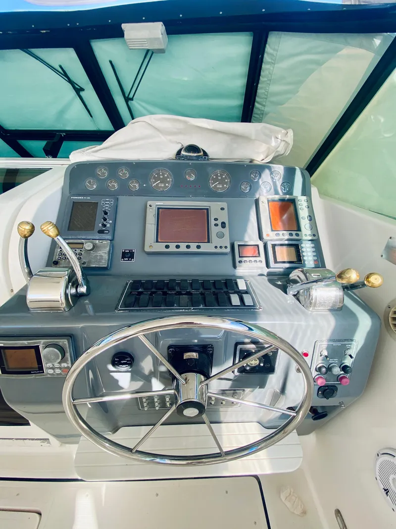 Slide: The Image of 1999 Tiara Yachts 43 Open helm with advanced navigation controls and steering wheel. - 41