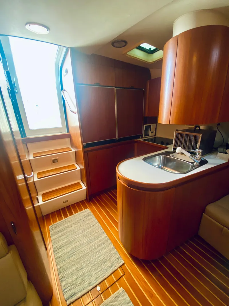 Slide: The Image of Interior of 1999 Tiara Yachts 43 Open, featuring wood cabinetry and modern kitchen amenities. - 46