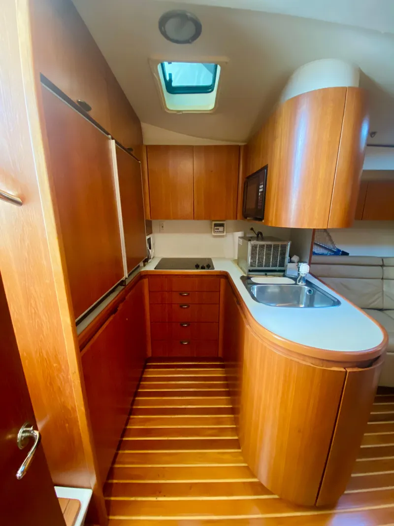 Slide: The Image of Luxurious 1999 Tiara Yachts 43 Open kitchen with wood cabinetry and modern amenities. - 47