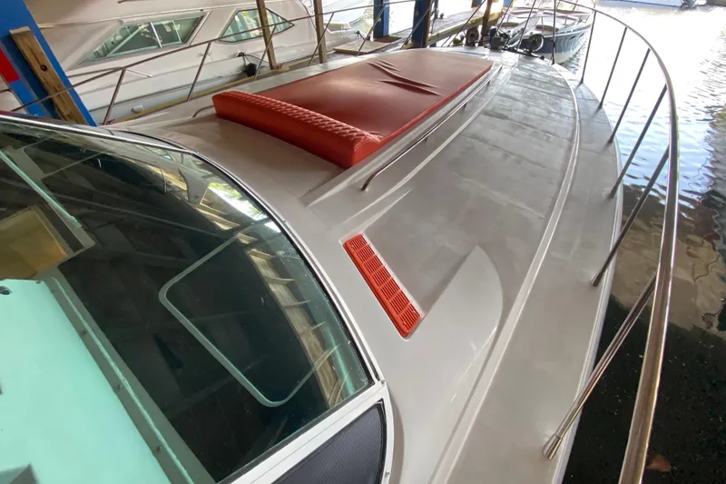 Slide: The Image of 1993 Wellcraft 4300 Portofino yacht docked, featuring sleek design and red cushion on deck. - 10