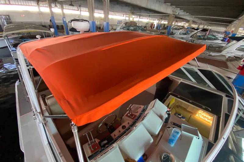 Slide: The Image of 1993 Wellcraft 4300 Portofino boat with orange canopy in marina setting. - 17