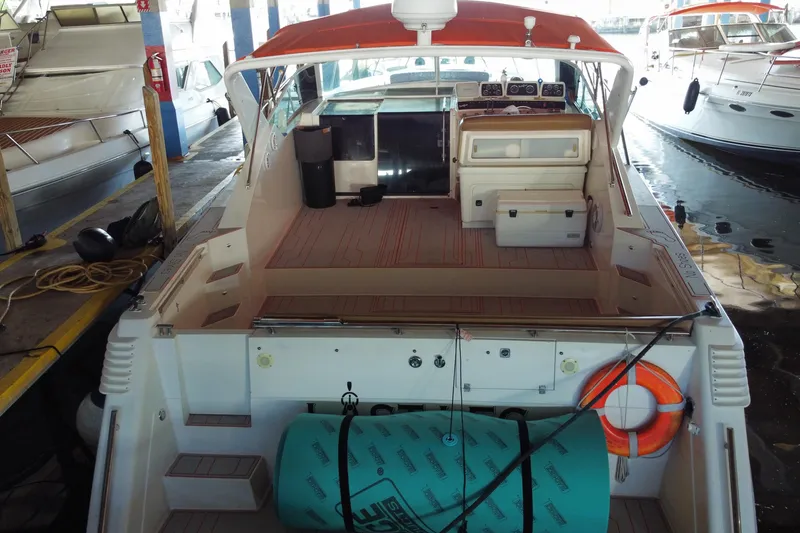 Slide: The Image of 1993 Wellcraft 4300 Portofino yacht with orange canopy, docked in a marina. - 19