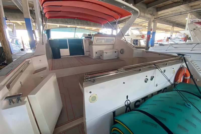 Slide: The Image of 1993 Wellcraft 4300 Portofino yacht with red canopy, docked in a marina. - 26