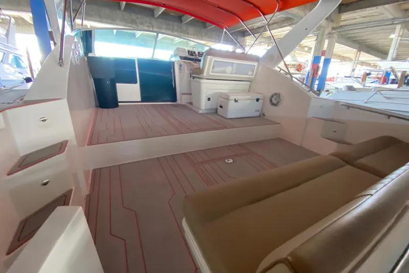 Slide: The Image of 1993 Wellcraft 4300 Portofino boat interior with seating and helm under a red canopy. - 27