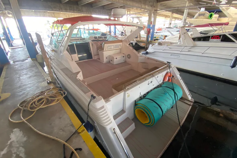 Slide: The Image of 1993 Wellcraft 4300 Portofino yacht docked in a marina, featuring spacious deck and seating. - 28