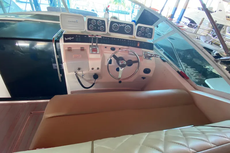 Slide: The Image of 1993 Wellcraft 4300 Portofino boat cockpit with steering wheel and navigation instruments. - 30