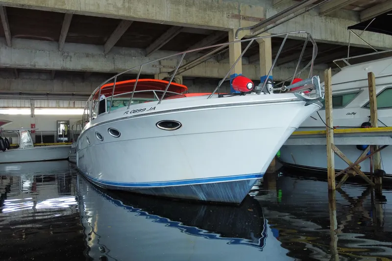 Slide: The Image of 1993 Wellcraft 4300 Portofino yacht docked in a marina under a concrete roof. - 5