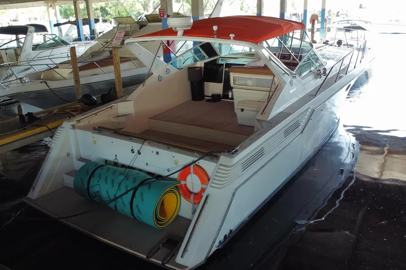 Slide: The Image of 1993 Wellcraft 4300 Portofino yacht with orange canopy docked in a marina. - 55