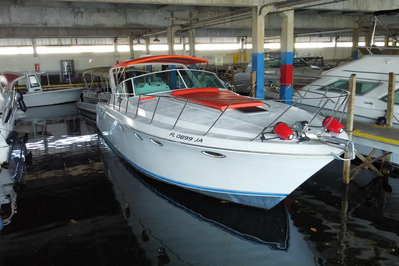 Slide: The Image of 1993 Wellcraft 4300 Portofino yacht docked in a marina, featuring red accents. - 6