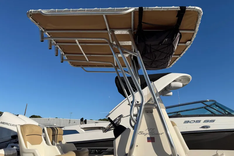 Slide: The Image of 2016 Pioneer 175 Bay Sport boat with T-top and seating, under clear blue sky. - 5