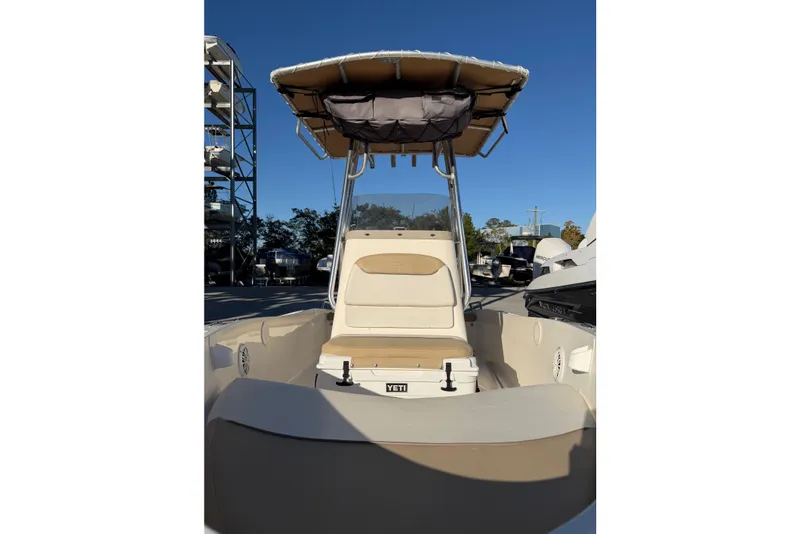 Slide: The Image of 2016 Pioneer 175 Bay Sport boat with T-top and seating, docked under clear blue sky. - 6