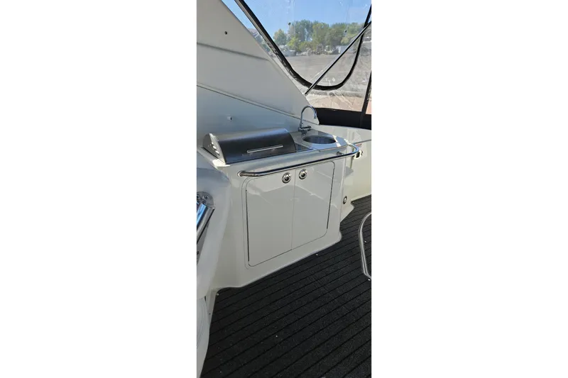 Slide: The Image of 2009 Sea Ray 270 Sundancer boat interior with sink and grill setup. - 10