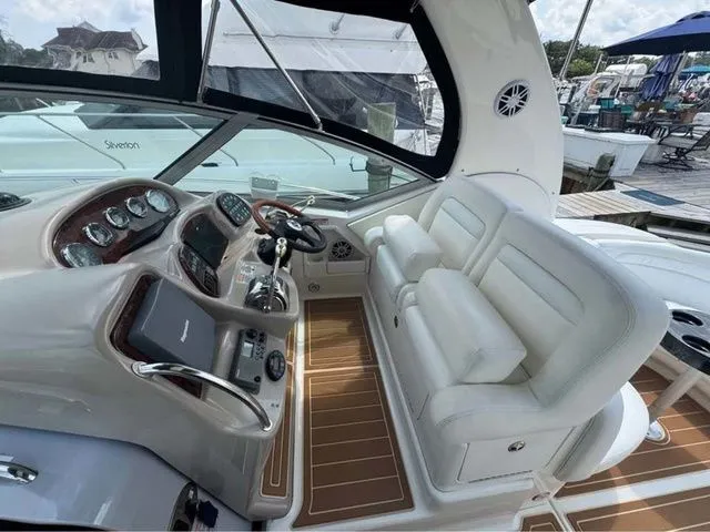 Slide: The Image of 2004 Sea Ray 320 Sundancer cockpit with white seating and modern controls. - 5