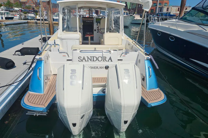 Slide: The Image of 2023 MJM 35 boat with twin Mercury 300 engines docked at a marina. - 13