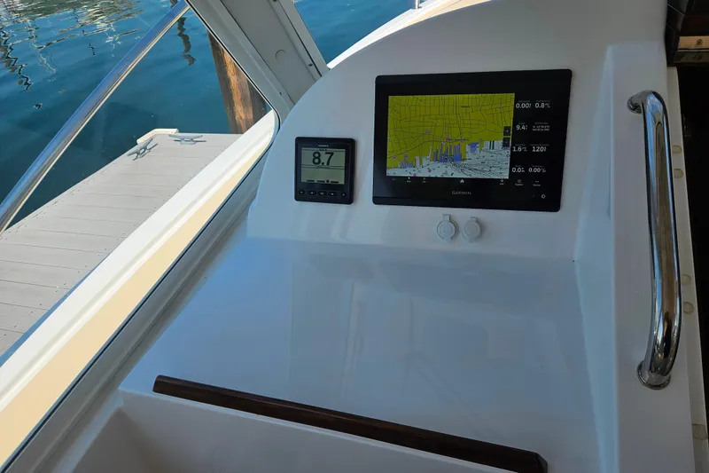 Slide: The Image of 2023 MJM 35 boat dashboard with Garmin navigation display and speedometer. - 36