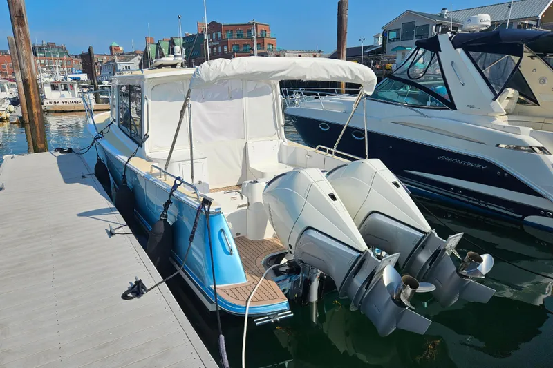 Slide: The Image of 2023 MJM 35 boat docked with twin outboard engines in a marina setting. - 44
