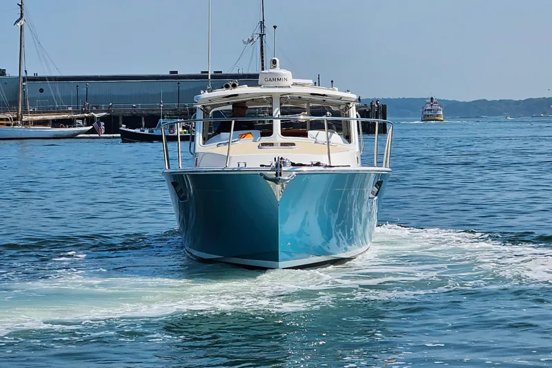 Slide: The Image of 2023 MJM 35 boat cruising in a harbor with clear blue water. - 6