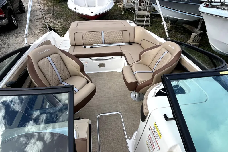 Slide: The Image of 2016 Sea Ray 220 Sundeck interior with beige seating and open deck layout. - 12
