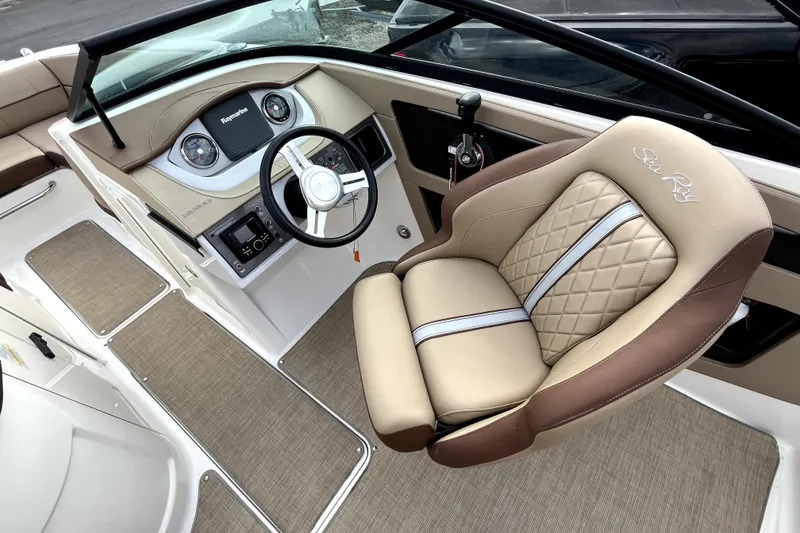 Slide: The Image of 2016 Sea Ray 220 Sundeck cockpit with steering wheel and luxurious seating. - 13