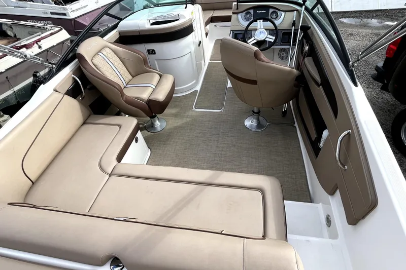 Slide: The Image of 2016 Sea Ray 220 Sundeck interior with beige seating and modern dashboard. - 18
