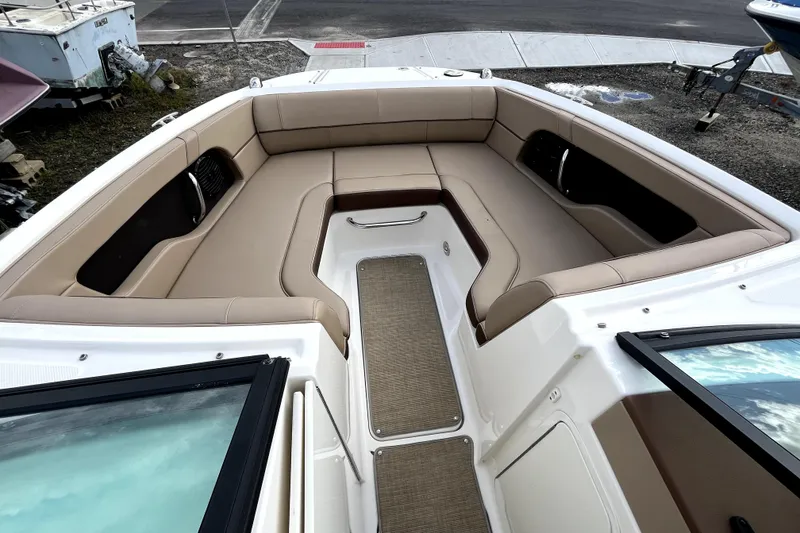 Slide: The Image of 2016 Sea Ray 220 Sundeck boat interior with beige seating and carpeted floor. - 7