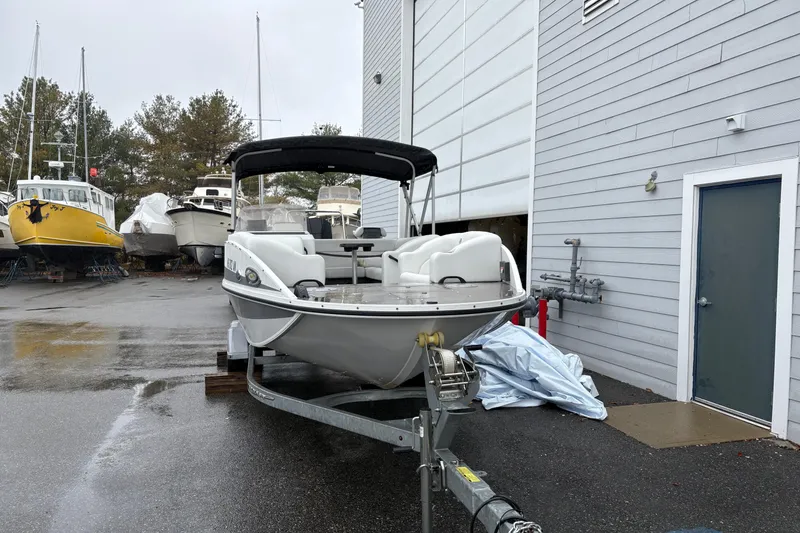 Slide: The Image of 2022 Princecraft Ventura 224 boat on trailer, parked near a building in a marina. - 1