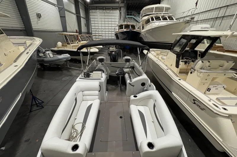 Slide: The Image of 2022 Princecraft Ventura 224 boat in a showroom, surrounded by other boats. - 11