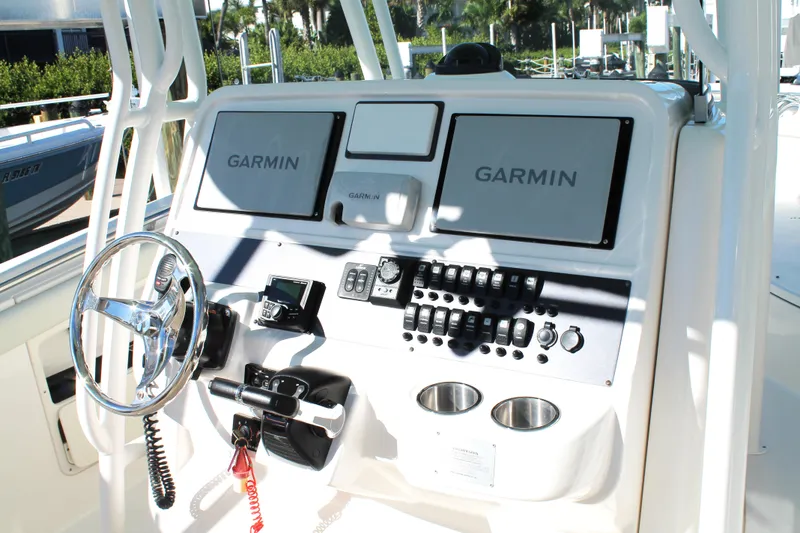 Slide: The Image of 2016 Robalo R300 Center Console boat dashboard with Garmin displays and controls. - 22