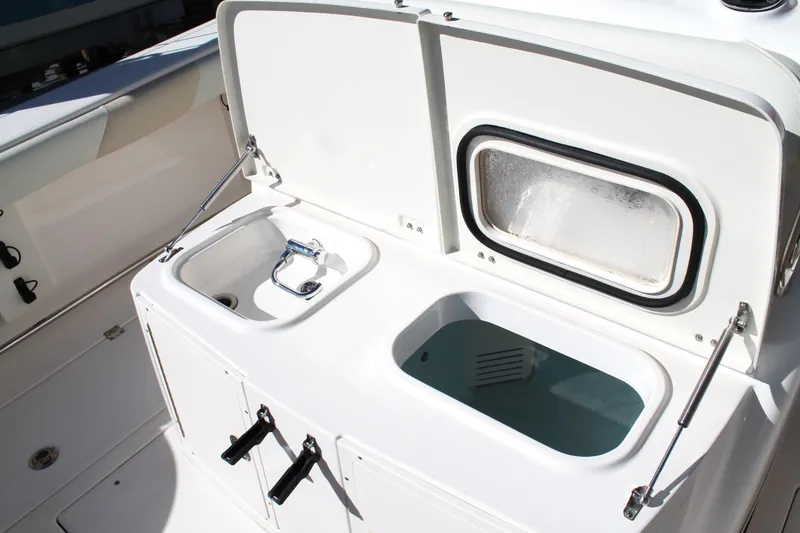 Slide: The Image of 2016 Robalo R300 Center Console boat with open storage compartments. - 27