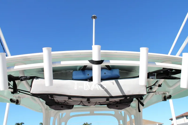 Slide: The Image of 2016 Robalo R300 Center Console boat with rod holders and storage, under clear blue sky. - 32