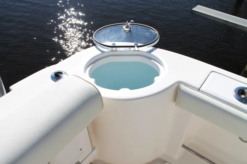 Slide: The Image of 2016 Robalo R300 Center Console boat with open livewell, sparkling water reflection. - 34