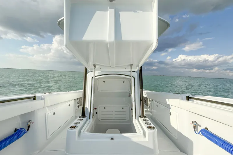 Slide: The Image of 2026 Yellowfin 34 Offshore boat with open storage compartment, ocean view, and cloudy sky. - 19