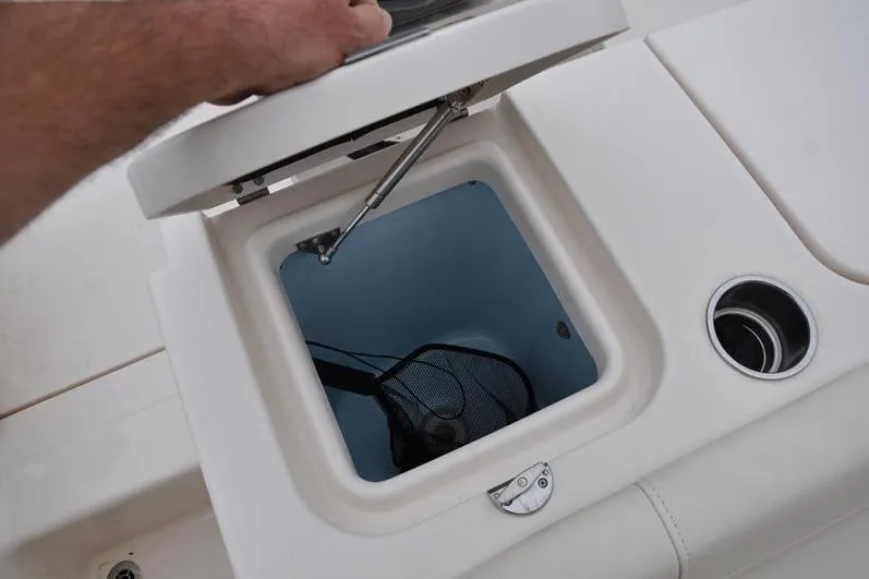 Slide: The Image of Livewell compartment on a 2022 Grady-White Freedom 235 boat, featuring a net and cup holder. - 12