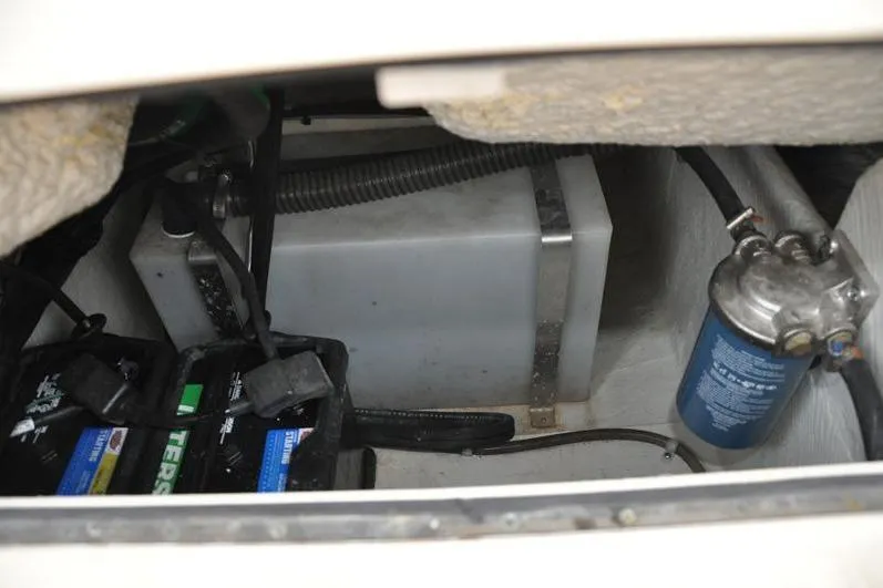 Slide: The Image of 2022 Grady-White Freedom 235 boat battery compartment with wiring and filter. - 16