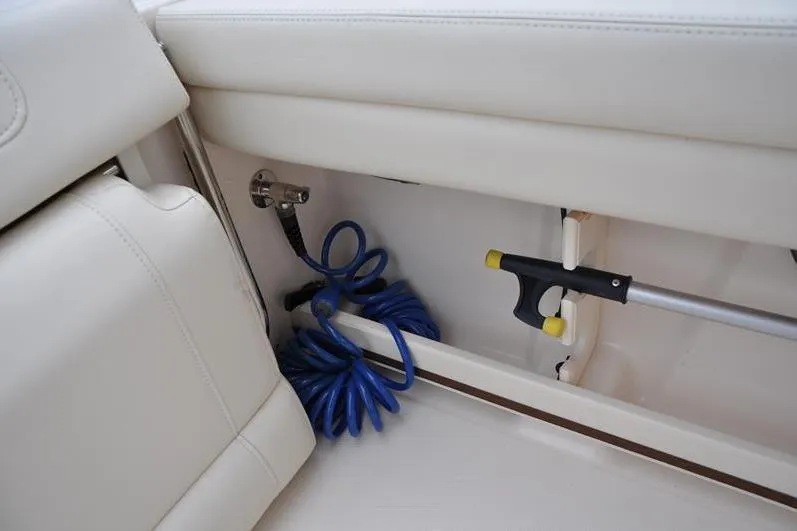 Slide: The Image of Interior storage of 2022 Grady-White Freedom 235 boat with coiled blue hose. - 17