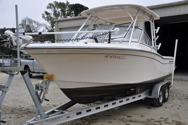 Slide: The Image of 2022 Grady-White Freedom 235 boat on trailer, parked outdoors near a garage. - 8