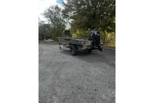 Slide: The Image of 2026 Tracker Grizzly 1650 T Prairie Wings Edition boat in a parking area. - 2