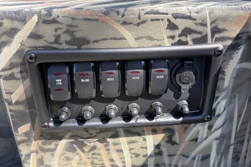 Slide: The Image of Control panel of 2026 Tracker Grizzly 1650 T Prairie Wings Edition with switches and 12V outlet. - 26