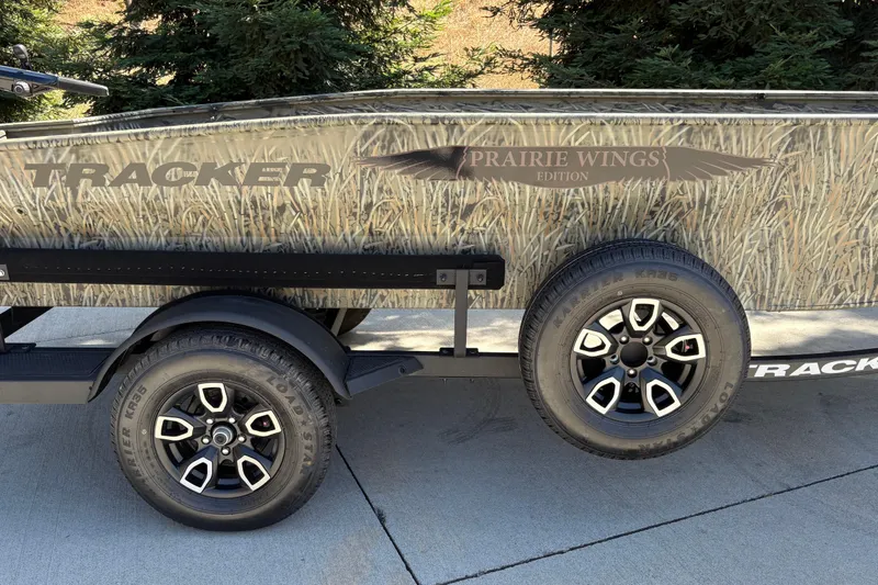 Slide: The Image of 2026 Tracker Grizzly 1650 T Prairie Wings Edition with camouflage design and dual wheels. - 12