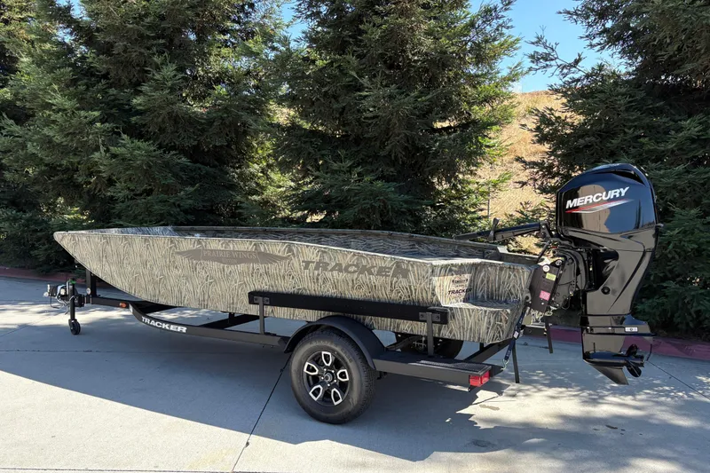 Slide: The Image of 2026 Tracker Grizzly 1650 T Prairie Wings Edition boat with Mercury engine on trailer. - 2